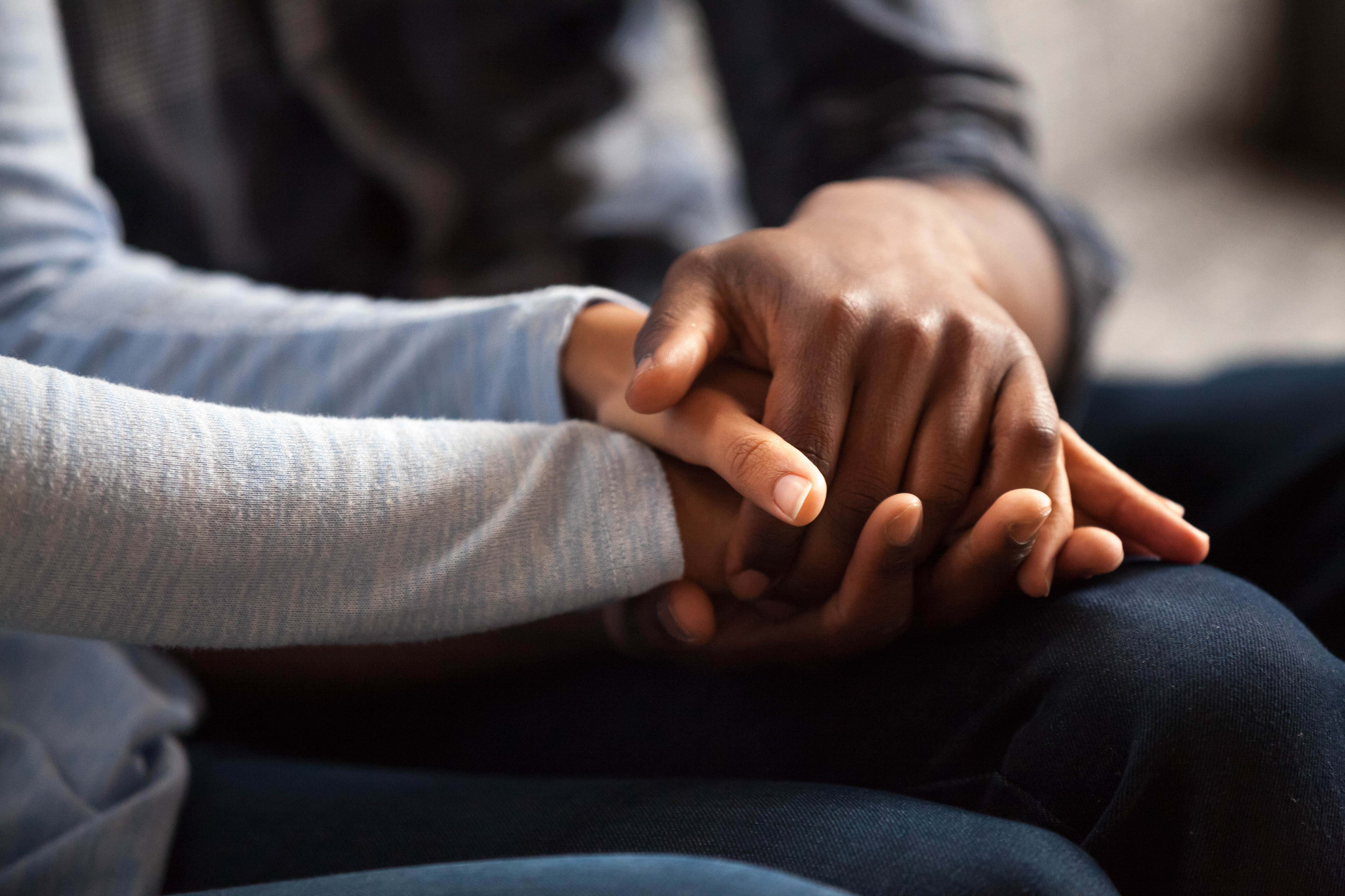Close-up of couples hands while sitting getting bad news in a doctor's office Close-up of couples hands while sitting getting bad news in a doctor's office